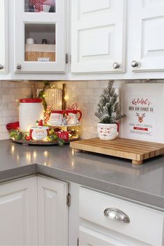 a kitchen counter with white cabinets and christmas decorations