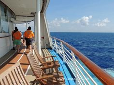 two people are standing on the deck of a cruise ship looking out at the ocean