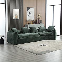 a living room filled with green couches and rugs on top of hard wood flooring