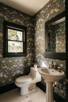 a bathroom with a toilet, sink and mirror in it's center wallpaper