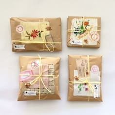 three packages wrapped in brown paper tied with twine and ribbons, each containing different designs