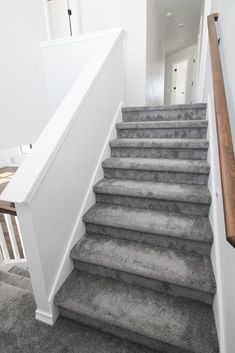 there is a set of stairs leading up to the second floor in this house with carpeted floors