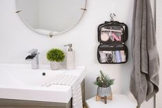 a bathroom with a sink, mirror and toiletries in the holder on the wall