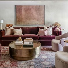 a living room filled with furniture and a painting on the wall above it's coffee table