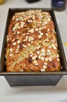 a loaf of oatmeal bread sitting in a pan on a counter top