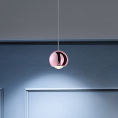 a pink light hanging from the ceiling in a room with blue walls and white trim