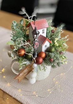 a small christmas arrangement in a mug on a table