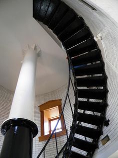 a spiral staircase leading up to a window