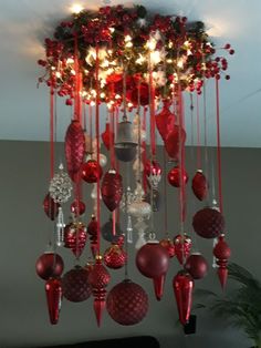 a chandelier with red ornaments hanging from it