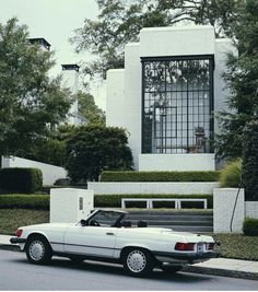 a white car parked in front of a house