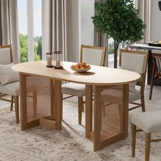 a dining room table with two chairs and a bowl of fruit on the table next to it