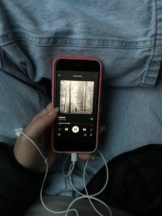 a person is holding an mp3 player in their lap and listening to music on the phone