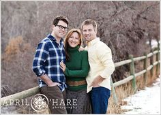 three people standing next to each other near a fence