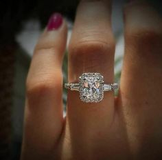 a woman's hand with a diamond ring on it