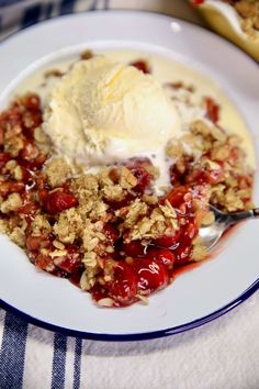 a white plate topped with fruit and ice cream on top of a blue and white table cloth