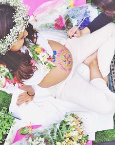 a woman laying on the ground with flowers in her hair