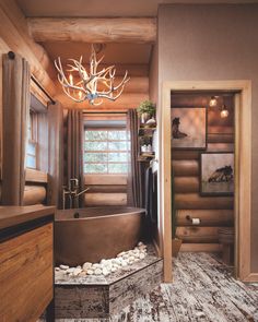 the bathroom is decorated in rustic wood and has a large tub with rocks on it