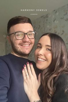 a man and woman are smiling for the camera with their hands on each other's shoulders