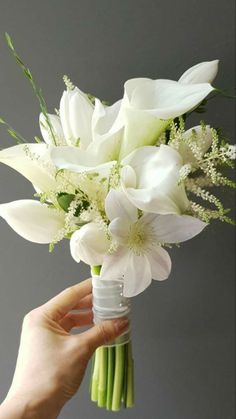 a person holding a bouquet of white flowers