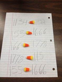 a piece of paper with candy corn on it and the numbers written in front of them