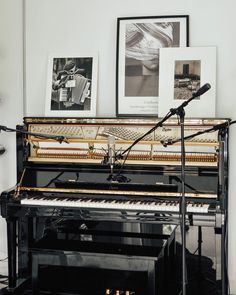 a piano and microphone in front of two pictures on the wall