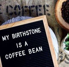 a sign that says, my birth stone is a coffee bean next to some beans