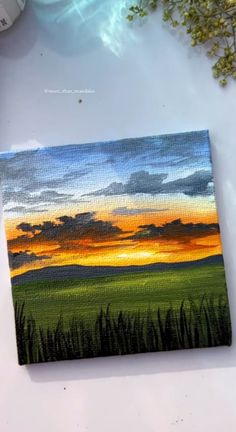 an acrylic painting of a sunset over a green field