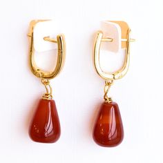 Free Shipping in the US These exquisite red carnelian and gold earrings feature teardrop-shaped carnelian stones that add a touch of elegance and sophistication. The rich red hues of the carnelian are beautifully complemented by the gold settings. The earrings are secured with a sleek, modern gold hook, ensuring both style and comfort. Perfect for both casual and formal occasions, these earrings are a versatile addition to any jewelry collection, offering a timeless look with a contemporary twis Elegant Gold Carnelian Earrings, Red Drop Earrings, Gold Teardrop Agate Jewelry, Elegant Carnelian Earrings, Gold Carnelian Gemstone Earrings, Red Chalcedony Jewelry With Natural Stones, Red Teardrop Natural Stone Jewelry, Gold Teardrop Agate Earrings, Gold Agate Teardrop Earrings