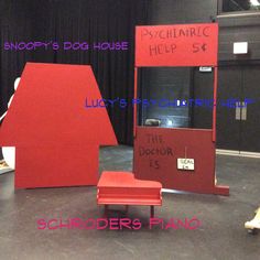 a red chair sitting in front of a sign that says snoopy's dog house