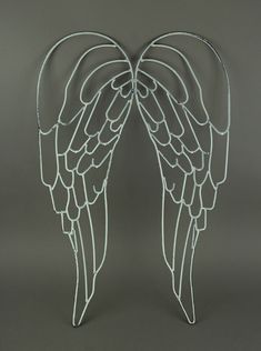 two metal angel wings on a gray background