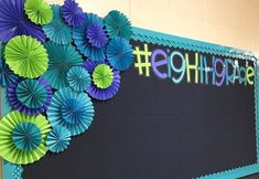 a bulletin board with paper flowers on it and the word high school written in purple