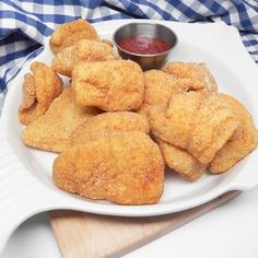 fried chicken nuggets on a white plate next to ketchup and dipping sauce