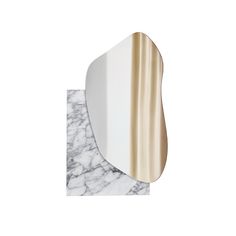 a white and gold mirror sitting on top of a marble counter next to a wall