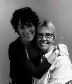 black and white photograph of two women hugging each other with their arms around one another