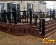 a deck with black railing and wooden steps