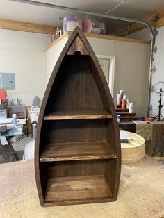 a boat shaped shelf sitting on top of a wooden table