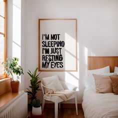 a bed room with a neatly made bed and a poster on the wall above it