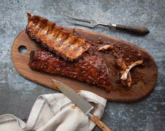 ribs on a cutting board with knife and fork