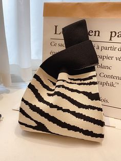 a black and white bag sitting on top of a table next to a sign that says le parfait