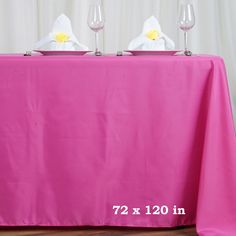 the table is covered with pink cloth and white napkins