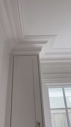 the corner of a room with white painted walls and trimmings on the ceiling