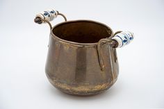 an old brown cup with two handles on the top and one handle is holding something in it