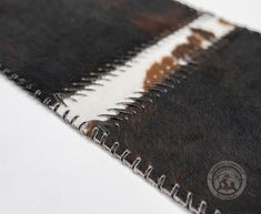 an old black and white striped rug on the floor with some brown stains all over it