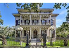 a large white house with black iron gates