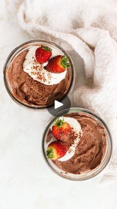 two bowls filled with chocolate pudding and topped with strawberries