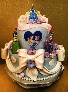 this is a cake with princess figurines on the top and decorations around it