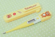 a yellow thermometer with an animal on it next to a small orange bear