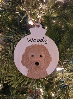 a dog ornament hanging from a christmas tree with the words woody on it