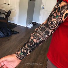 a man's arm with tattoos on it and an evil face in the middle