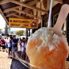 an orange and white ice cream sundae on a plate with people in the background